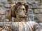 Ancient marble statue of a nobleman on a background of stone wall of Peles Castle in Sinaia, Prahova County,Â Romania